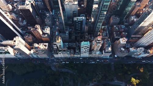 Scenic view of the Midtown Manhattan skyline during golden hour, with sunlight reflecting brightly off a skyscraper and shimmering on the East River, featuring the Chrysler Building and other iconic t
