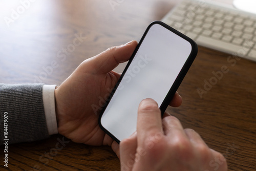 hands holding mobile phone with empty blank white screen, closeup, man using smartphone