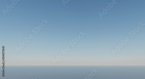 A vast, clear, light blue sky meets a pale, hazy horizon