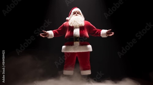 Santa claus in spotlight on dark stage with smoke against black background, concept of dramatic performance and showmanship