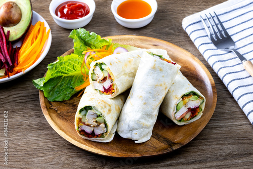 Obraz na płótnie Chicken breast with caesar dressing and lettuce in a gluten-free tortilla wrap,