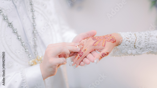 the groom puts the ring on the bride