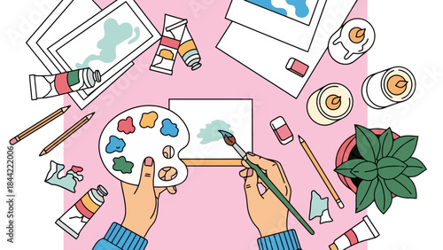 Top View of Artist's Hands Painting on Canvas with Art Supplies and Plants