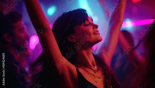 Woman joyfully dances with raised arms in the midst of a vibrant party.