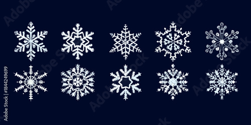 A collection of intricately designed white snowflakes on a dark blue background
