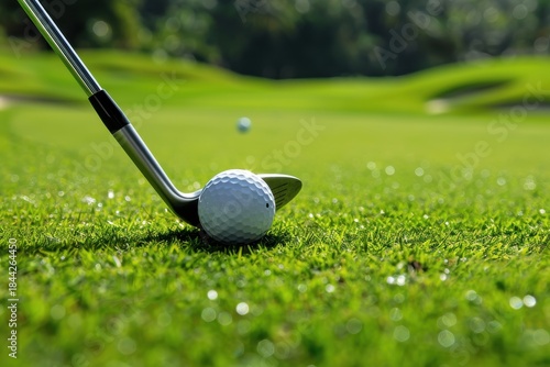 A close-up of a golf ball lined up with a club on a lush green course, ready for a clean shot toward the hole.