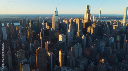Aerial view showing the Brooklyn Bridge spanning the East River, with its ramp leading into Lower Manhattan, dominated by the towers of the Financial District and One World Trade Center