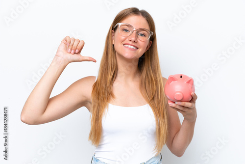 Young pretty blonde woman holding piggy bank isolated on white background proud and self-satisfied
