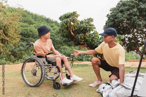 A caregiver assists a wheelchair user during camping setup at a scenic outdoor location. They share teamwork, trust, and inclusion while enjoying accessible travel and a relaxed lifestyle in nature.