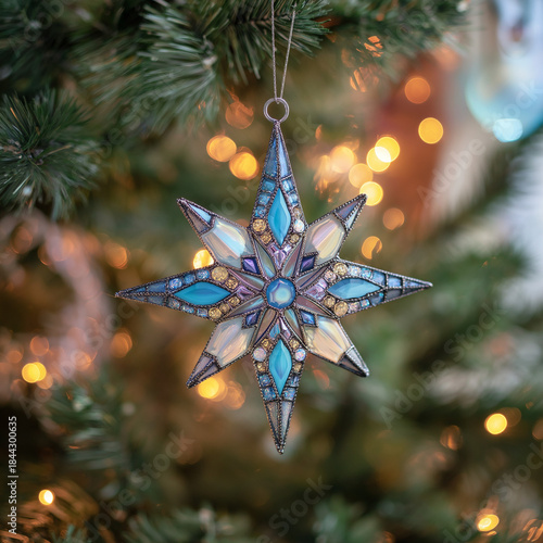 Stained glass star ornament hanging on Christmas tree with lights  