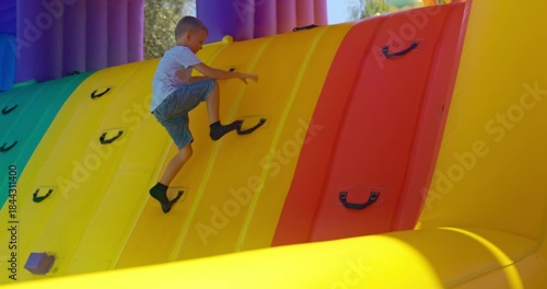 Child Climbing Inflatable Wall at Outdoor Playground