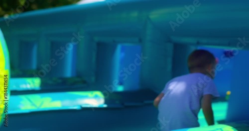 Child Enjoying Colorful Inflatable Obstacle Course Outdoors