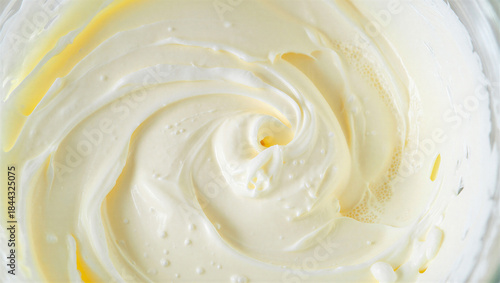 Swirled creamy white and yellow butter or frosting texture closeup