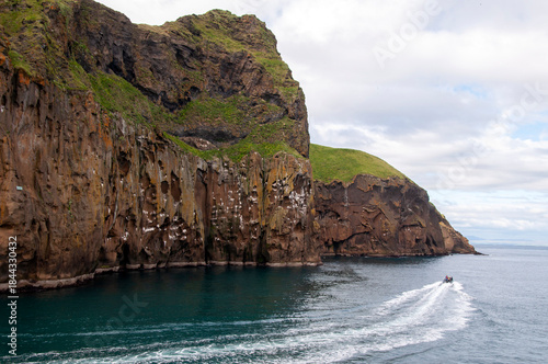 Vestmannaeyjar Iceland, view of cliffs from ocean with boat on water