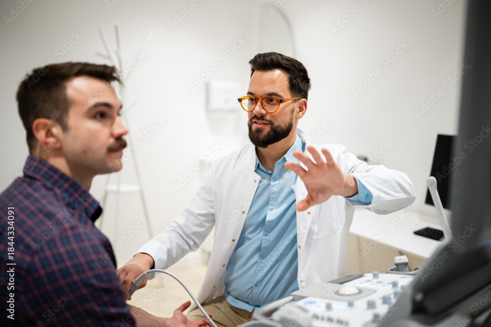 Obraz premium Doctor performing ultrasound examination on male patient arm