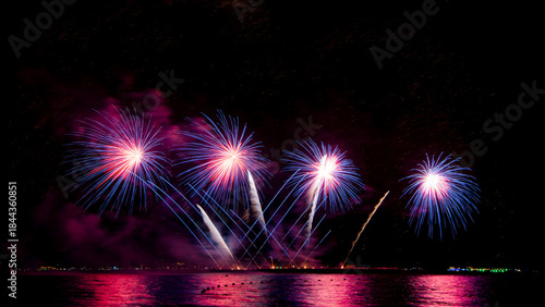 Amazing beautiful colorful firework display over sea on celebration night. Fireworks show for happy new year	