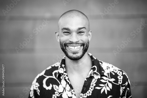 Black and white smiling portrait of a young male with floral shirt