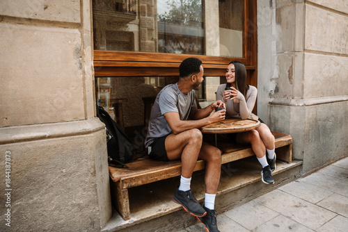 Photography Female athlete laughing and listening to male athlete while they hold cups and s