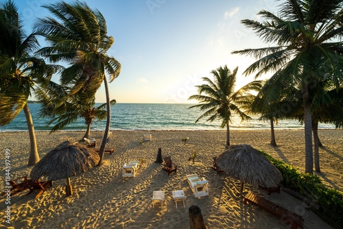 Plage de Placencia avec palmiers et chaises longues au lever du soleil, Bélize
