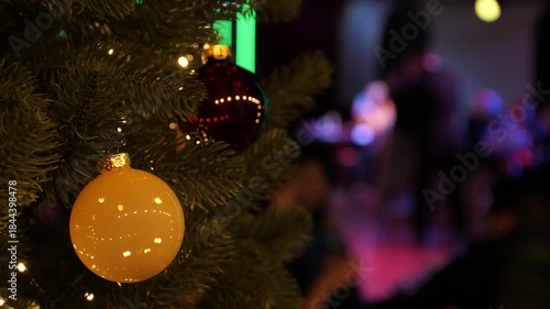 Christmas Glow and Tango Rhythm. Festive Tree Ornaments in Focus with a Dancing Tango Couple Blurred in the Background. Slow motion 2x