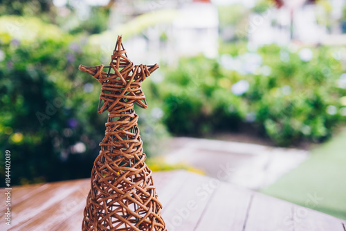 Closeup of handcrafted woven Christmas tree made from strong rattan material. Selective focus. Copy space.