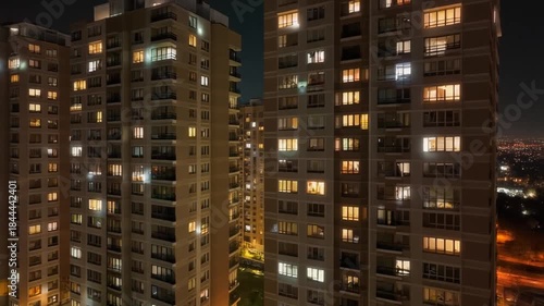 Evening View of Modern Residential Towers Illuminated with Interior Lights against Dark Sky