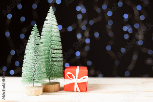 Small christmas trees on table against bokeh background