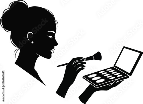 Silhouette of a woman applying makeup with a brush and palette.