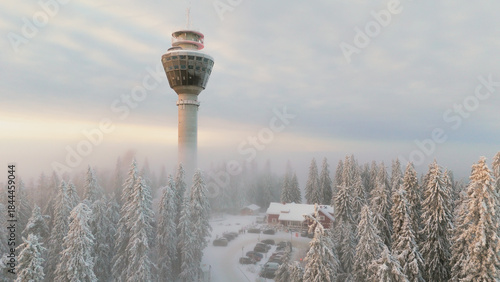 Scenic winter view of Puijo tower and cabin and surrounding snowy forest in Kuopio, Finland