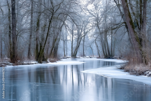 Serene winter river scene with icy banks and frosted trees.