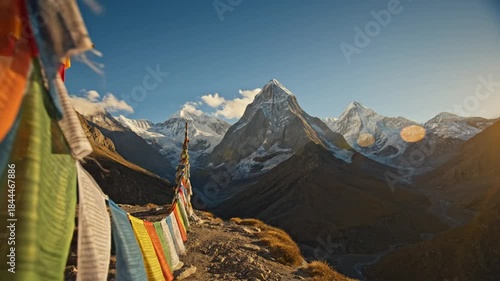 Scenic view of colorful prayer flags blowing in the wind with snow-capped mountains and clear blue sky in the background