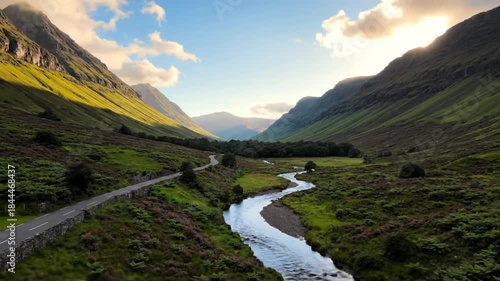 Scenic valley in scotland with river winding through lush green landscape under a bright blue sky with clouds