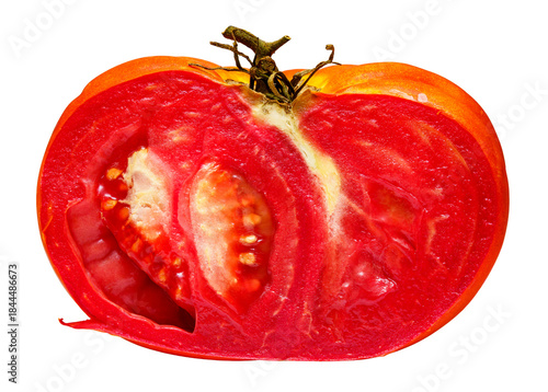Fresh tomato cut in half showing juicy red interior and seeds from a garden