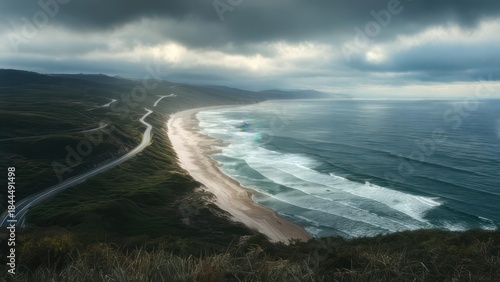 Coastal road winds along a dramatic beach under a stormy sky