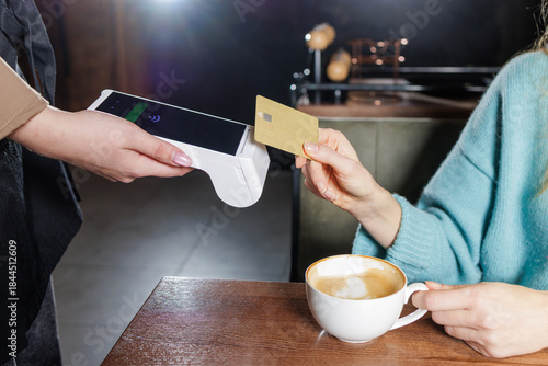 Fotografija Tableside NFC tap to pay card transaction with portable POS terminal in cafe