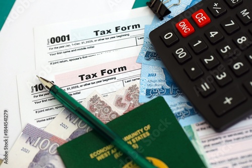 Nigerian naira money bills and calculator with tax form on flag close up. Taxation and accounting concept