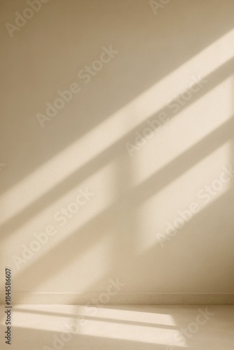 Minimal beige wall with soft window light and shadows, clean background with copy space for mockups.