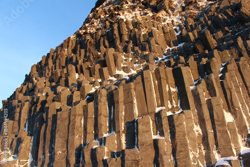 Basalt column formations with snow at Icelandic Black Sand Beach