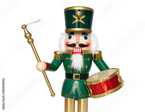 A wooden nutcracker soldier in green uniform with a drum and staff on a black background