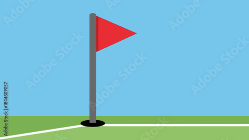 A red golf flag and ball sit on a green course under a blue sky near a road signpost indicating the way