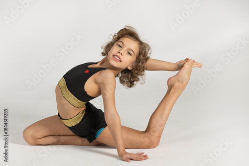 A girl in a tracksuit hones her skills. A woman practices rhythmic gymnastics.
