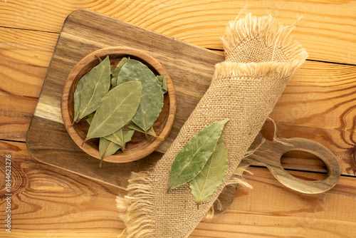 Dry bay leaf on a wooden table, close-up, top view.