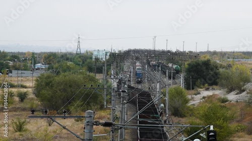 A busy railway station or junction. Trains are moving along the tracks.