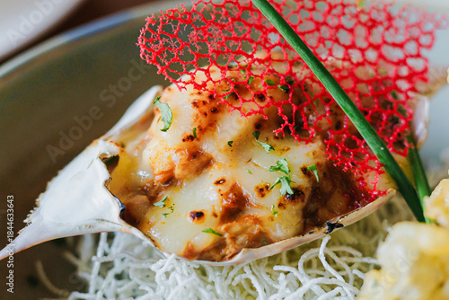 Gourmet seafood dish featuring baked shell, rich toppings, and decorative accents for culinary presentation and plating inspiration