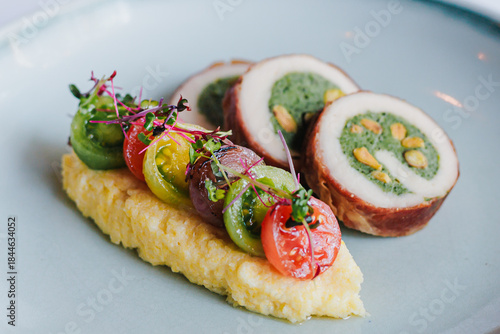 Deliciously Plated Chicken Roll with Spinach and Herb Garnish on a Modern Dish