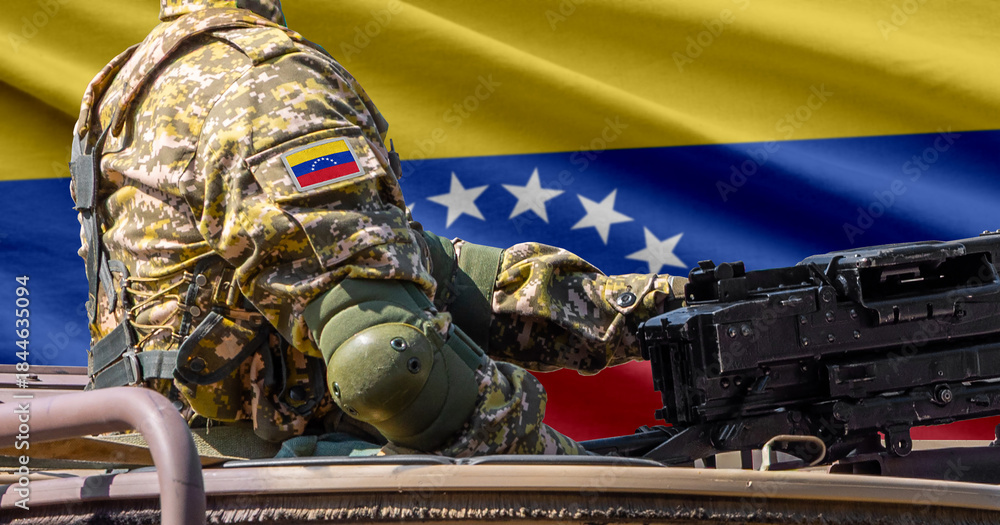 Naklejka premium Venezuela flag with soldier at machine gun turret in front of it. Closeup side view.