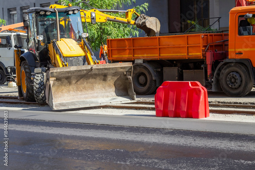 Road construction equipment on the road. A bulldozer, a dump truck, and an excavator.