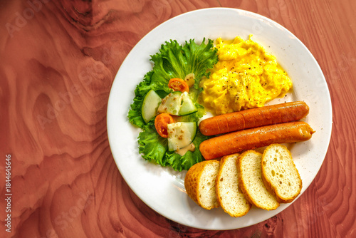 Breakfast plate with sausages, scrambled eggs, salad and toast