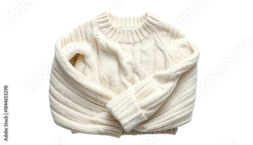 Cream-colored cable-knit sweater, folded and isolated on a black background