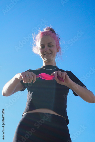 Morning outdoor fitness routine, woman training with resistance band in fresh air, simple daily exercise, active lifestyle, balance, wellness, self-care, and healthy habits.